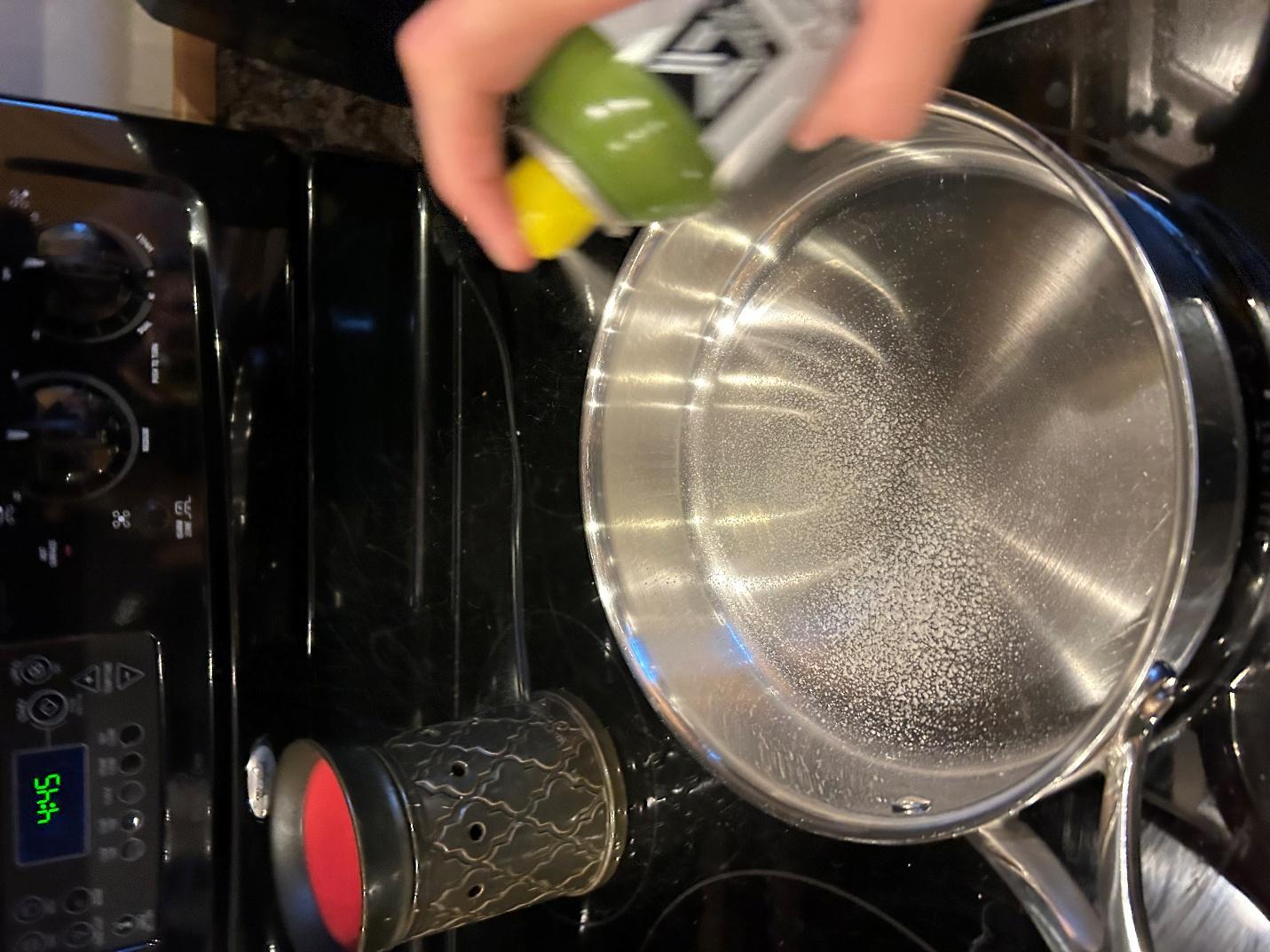 Spraying skillet with cooking spray
